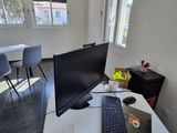 un bureau sur lequel se trouvent un ordinateur, un clavier, une souris et d'autres objets