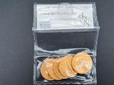 un gros plan sur un sac de pièces de monnaie d'où dépasse un billet d'un dollar