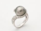 a black pearl and diamond ring on a white background