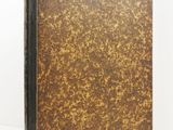 a brown and black book sitting on top of a white surface