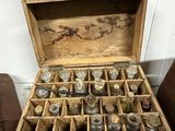 a wooden box filled with old metal items on the floor