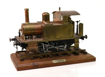 une petite maquette de machine à vapeur posée sur un socle en bois