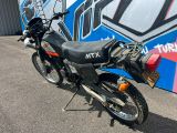 une moto garée devant un mur recouvert de graffitis