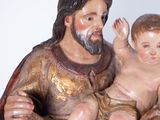 a statue of a man holding a baby in his lap