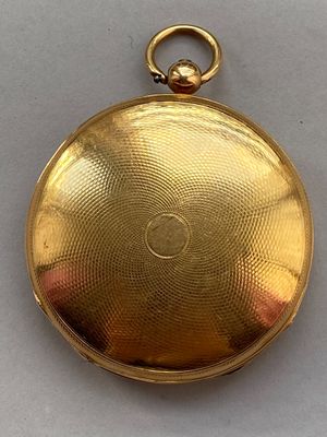 une image d'une montre de poche en or sur une surface blanche