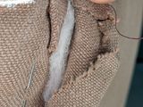 a person holding a needle and thread in their pocket
