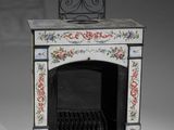 a small black fireplace with a floral design on it