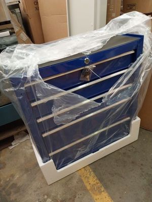 une boîte à outils bleue posée sur un chariot dans un entrepôt