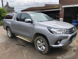 La Toyota Hilux est garée devant un immeuble en briques