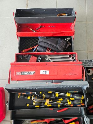 de nombreux outils dans une boîte à outils rouge posée par terre