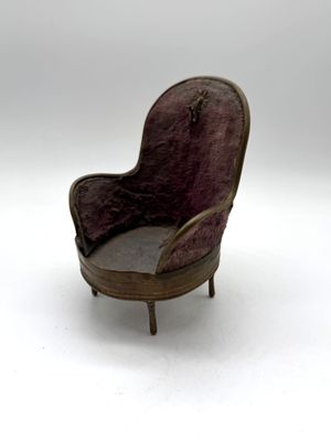a miniature chair that is sitting on a white surface