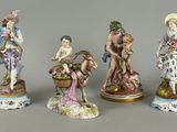 four porcelain figurines of a woman, a man, and a child