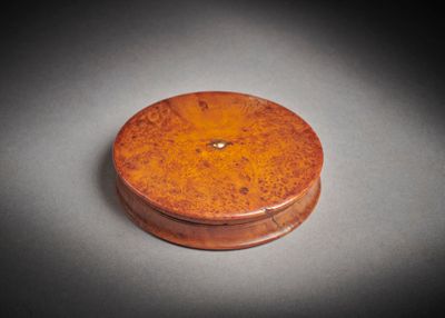 une vieille boîte en bois posée sur une table, elle-même posée sur une autre table