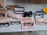 Plusieurs paires de lunettes sont posées sur une table à côté d'une paire de lunettes