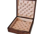 an open wooden box with a buttoned top and a buttoned lid