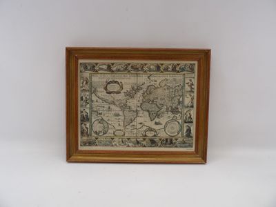 une vieille carte du monde dans un cadre en bois accrochée à un mur blanc