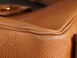 a close up of a brown leather suitcase with a handle