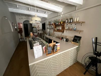 a photo of a bar with a lot of bottles on the counter