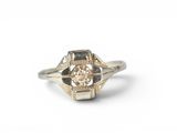 a close up of a ring with a diamond in it