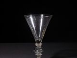 a wine glass sitting on a table with a black background
