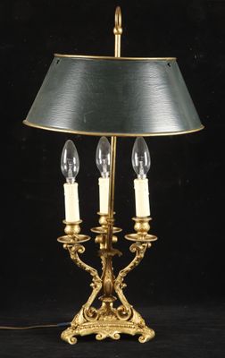 an antique brass table lamp with two candles on a black background