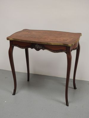 une petite table avec un plateau en bois posée sur un sol gris