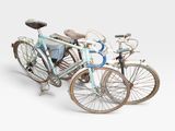 two bicycles parked next to each other on a white surface