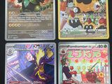 Quatre cartes Pokémon différentes sont posées sur une table.
