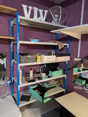 a room with a desk, shelves, and other items