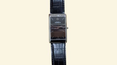 a black watch with a brown face on a black strap