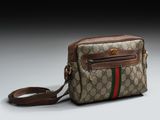 un sac marron et vert posé sur une table blanche