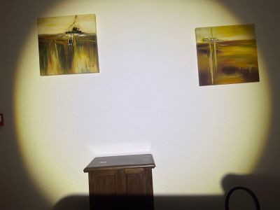 two paintings hanging on the wall above a small table