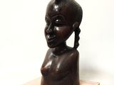 une image représentant une sculpture en bois représentant une tête de femme posée sur un socle en marbre