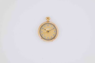 a close up of a gold watch on a white surface