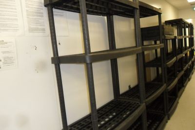 a long shelf with lots of boxes on it in a room