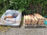 un tas de bois posé sur une palette à côté d'un sac en plastique