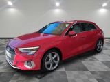 Une Audi rouge est garée sur un sol carrelé à damier.