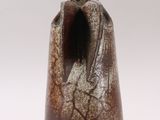 a brown vase that has a bird on top of it