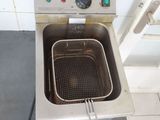a deep fryer sitting on the floor in a kitchen