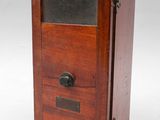 une vieille boîte en bois surmontée d'une porte vitrée