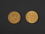 two pieces of gold coins on a black surface