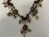 a close up of a necklace on a white surface