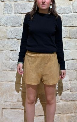 a young woman standing in front of a stone wall