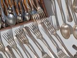 a lot of spoons and spoon knives on the table