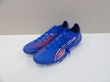 a pair of blue soccer shoes on a white surface
