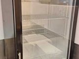 un réfrigérateur avec une porte vitrée au milieu d'une pièce