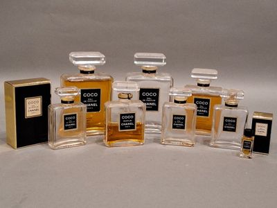 quatre flacons de parfum posés les uns à côté des autres sur une surface blanche