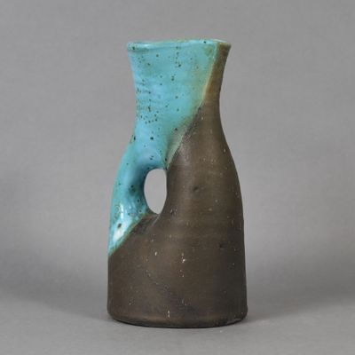 un vase bleu et marron qui a un trou
