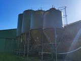 Le soleil brille de mille feux sur une ferme avec des silos au premier plan