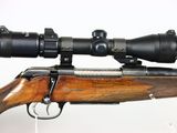 a close up of a rifle with a scope on a white background